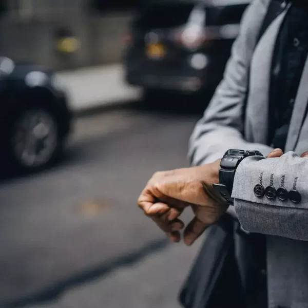 A guy in suit looking at the time