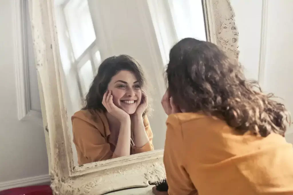 A woman looking the mirror and smiling