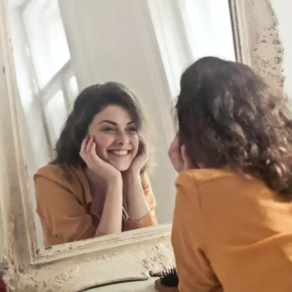 A woman looking the mirror and smiling