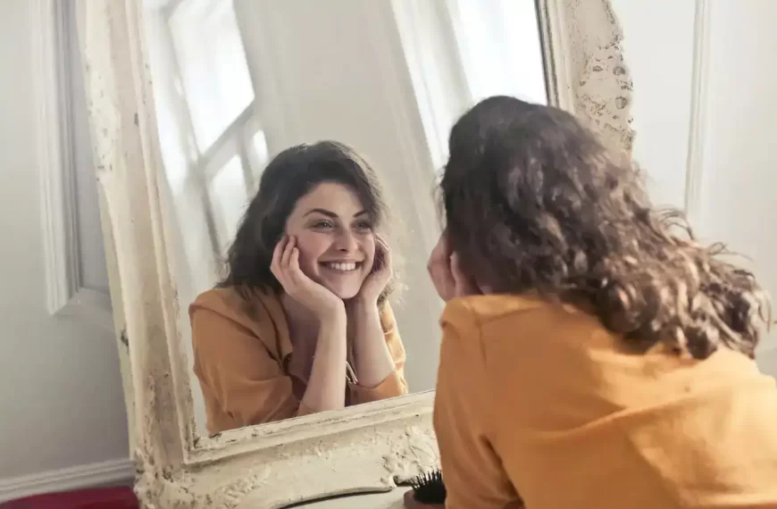 A woman looking the mirror and smiling