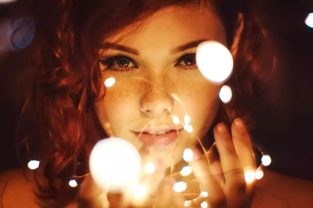 A close up of a girl holding fairy lights