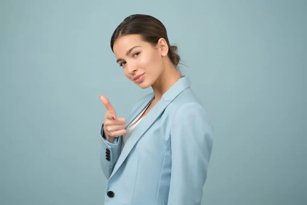 A woman pointing a finger at you with a smile on her face