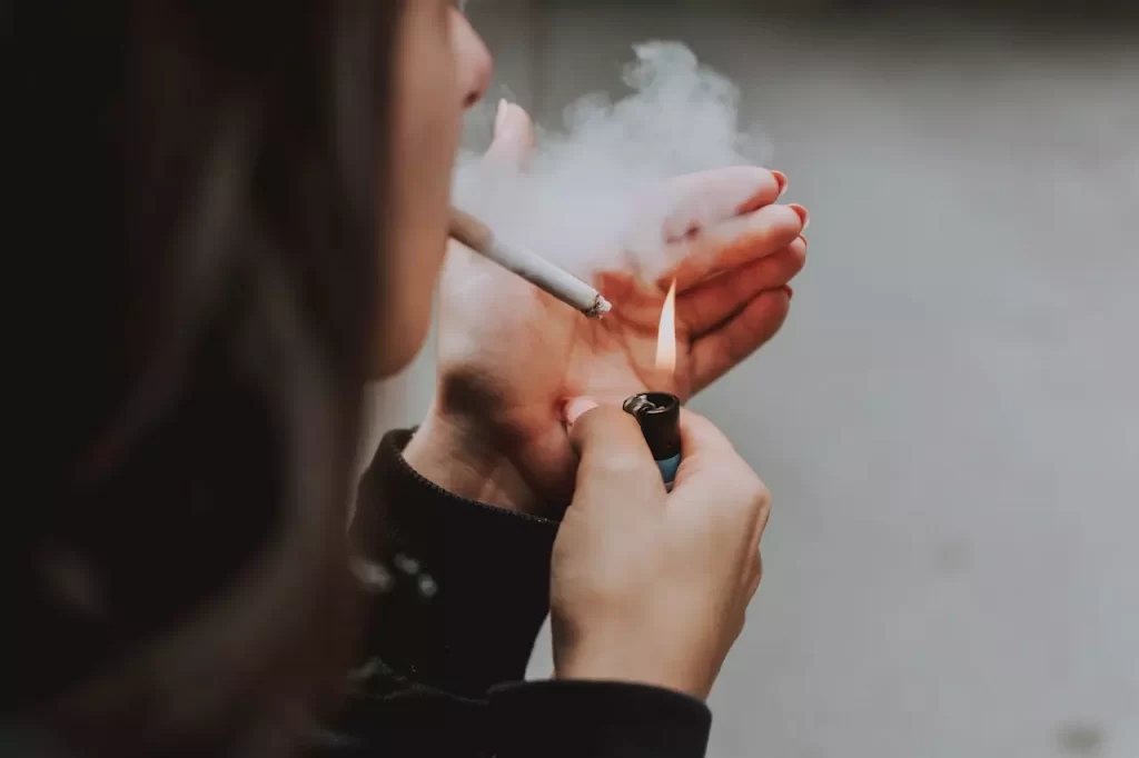 A girl lighting up a cigarette