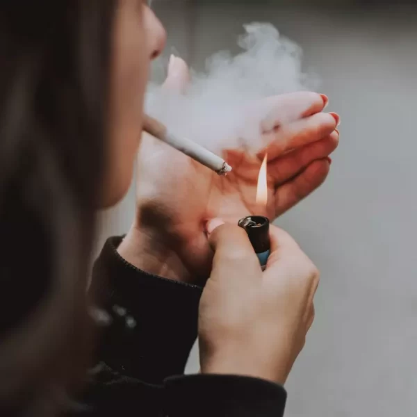 A girl lighting up a cigarette