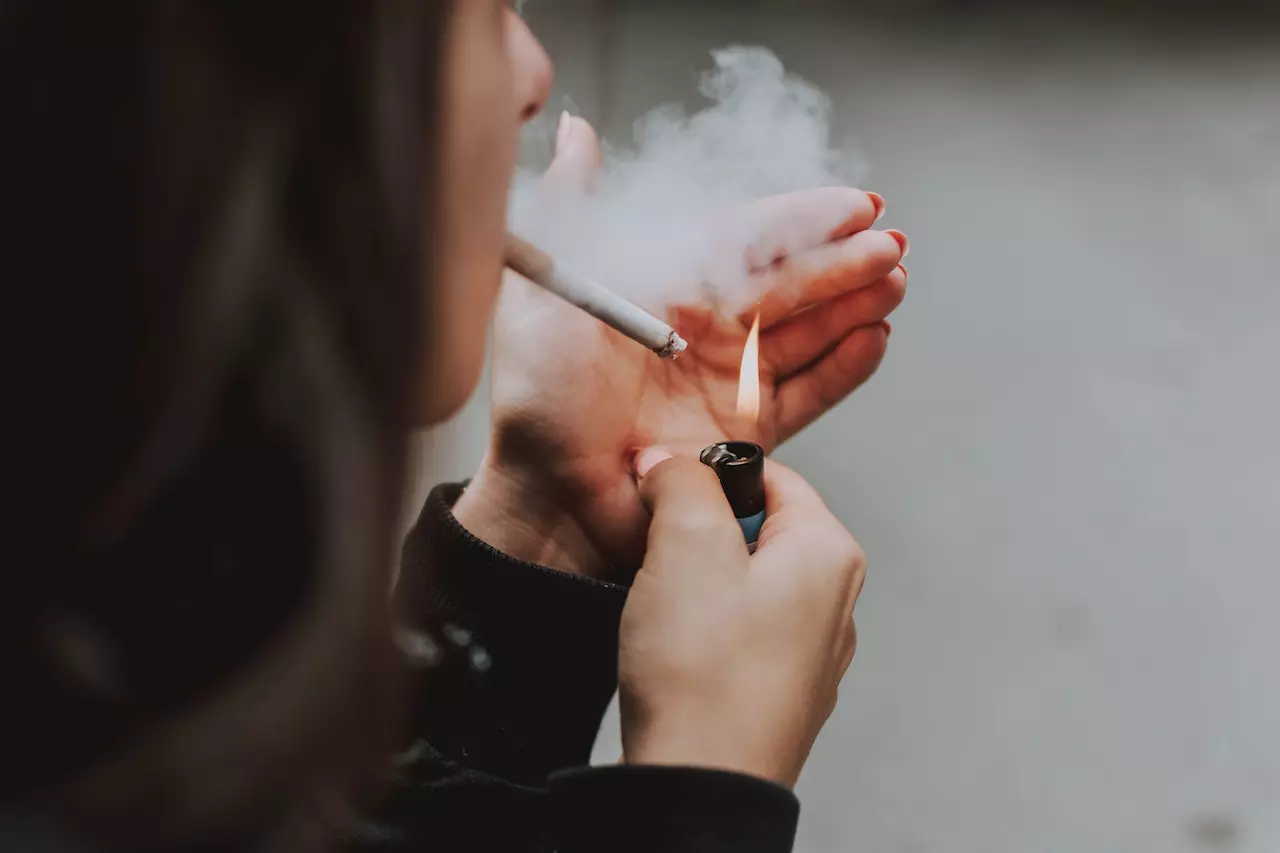 A girl lighting up a cigarette