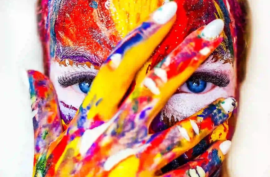 A close up of a girl with paint on her face and hand