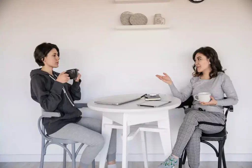 2 women having converstation with coffee in their hands