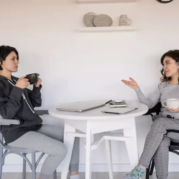 2 women having converstation with coffee in their hands