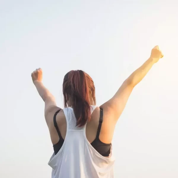 A woman in black and white tank top raising both her arm to the top