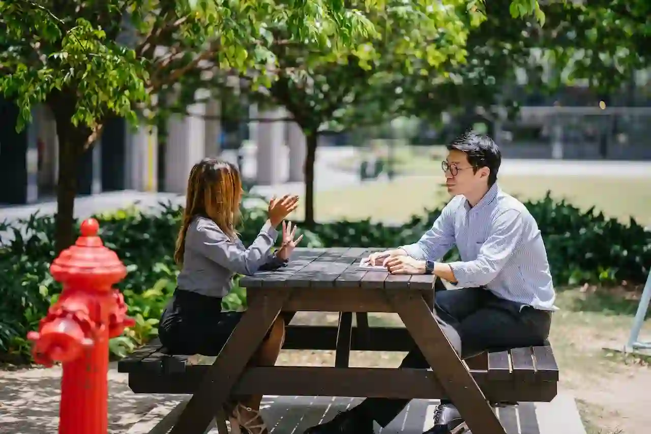 A guy and a girl sitting on a bench and having a conversation