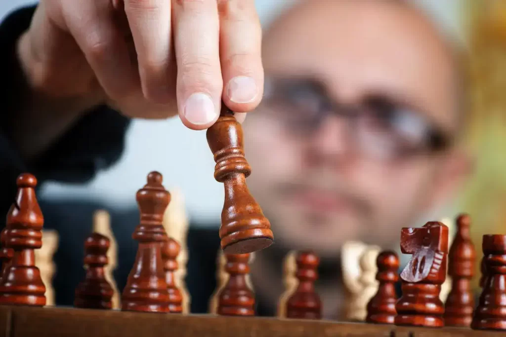 A man moving chess pieces on the table