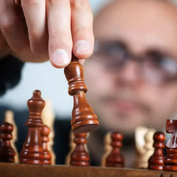 A man moving chess pieces on the table