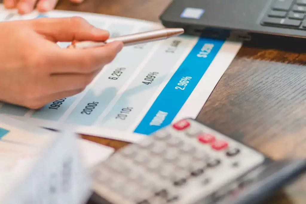 A close up shot of an agent pointing rates with a ballpen