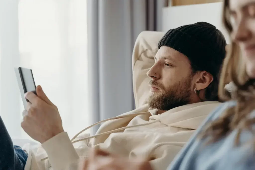 A man in bed looking at his cellphone