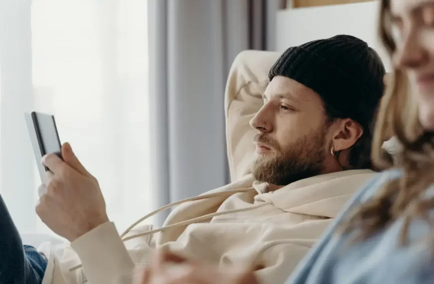 A man in bed looking at his cellphone