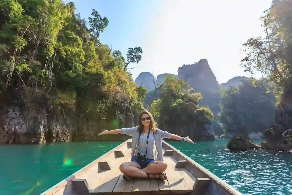 A woman sitting on a boat spreading her arms