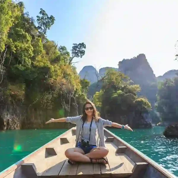 A woman sitting on a boat spreading her arms