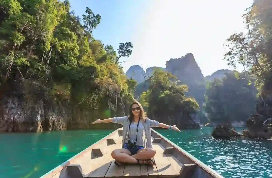 A woman sitting on a boat spreading her arms