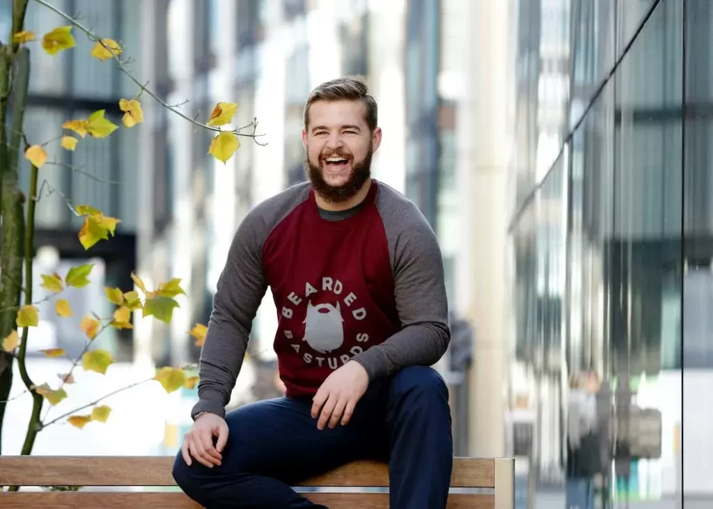 A guy sitting on a bench and laughing