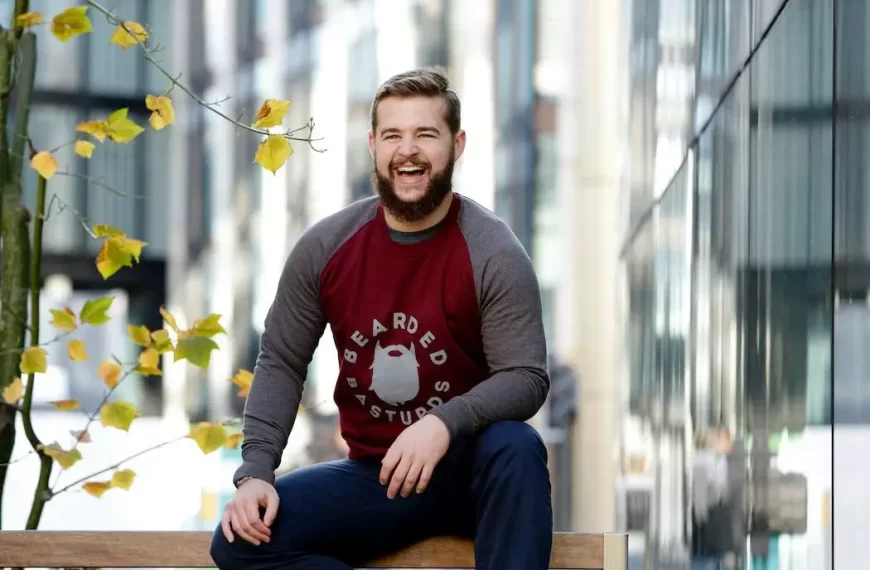 A guy sitting on a bench and laughing