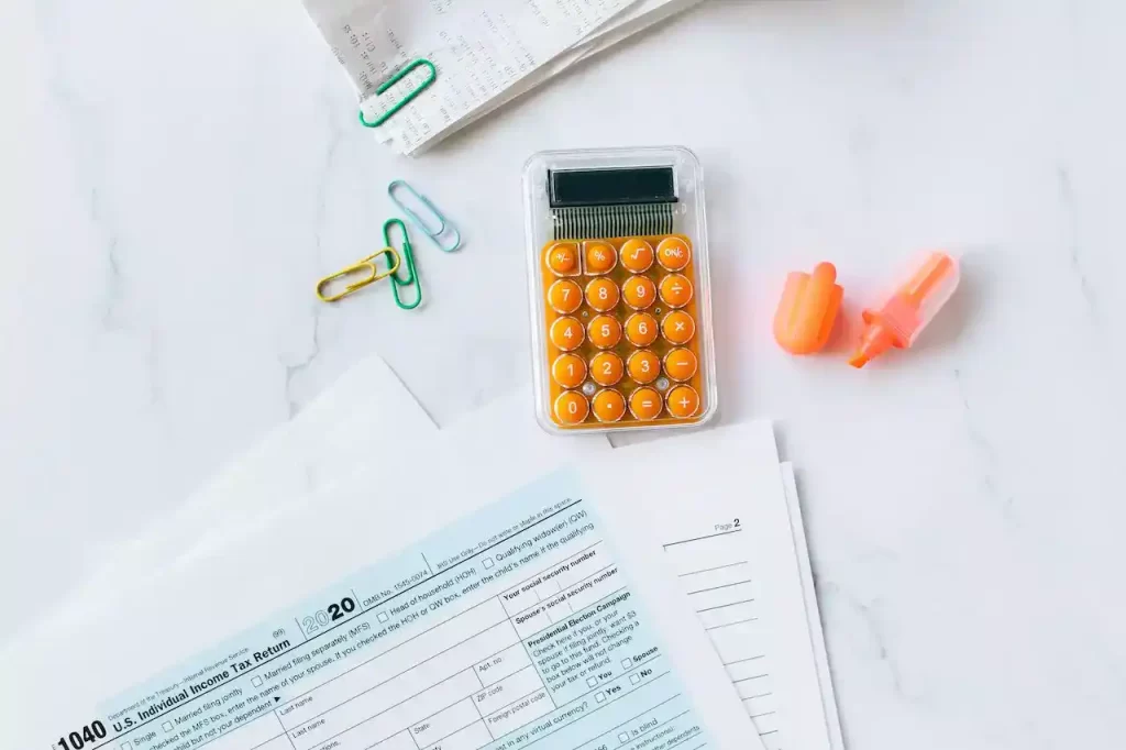 a calculator, highlighter, and bills on a table