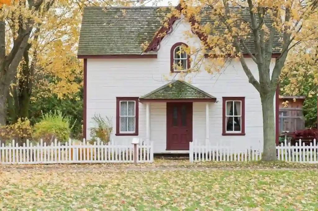 White and red wooden house with fence