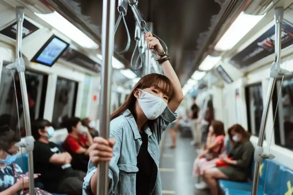 A woman wearing a face mask on a subway