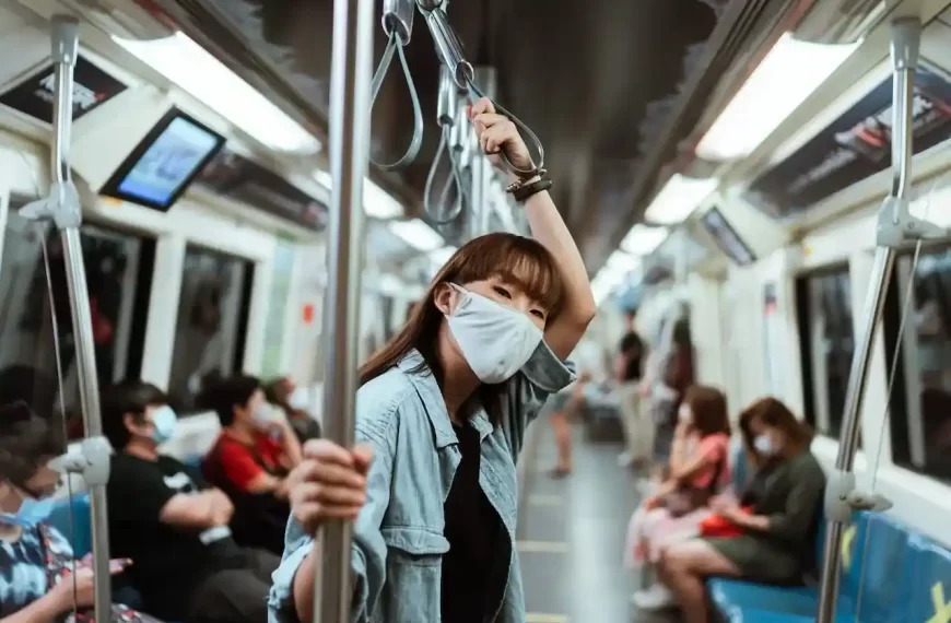 A woman wearing a face mask on a subway