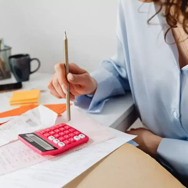 A woman computing bills while holding a pencil