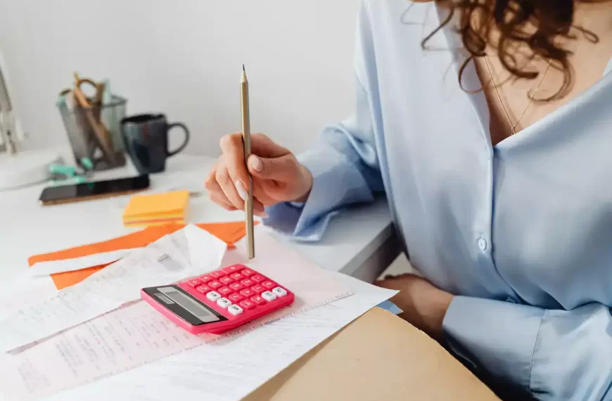 A woman computing bills while holding a pencil