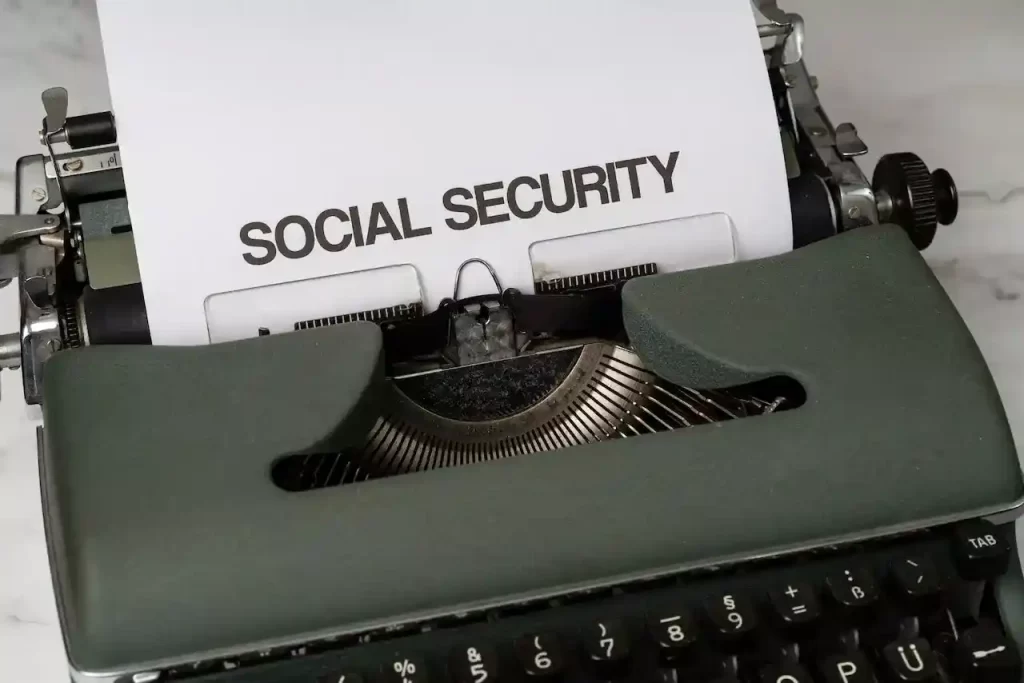 Green classic typewriter with white paper sying "Social Security" on it