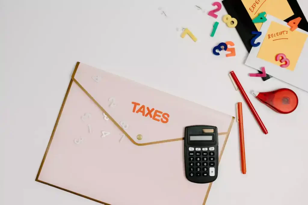 Black and gray calculator on a white paper with "taxes" written on it