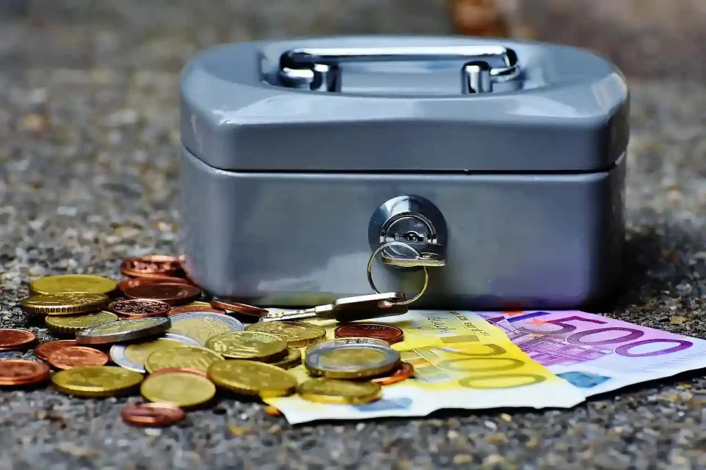 Cash box with coins and cash laying around it