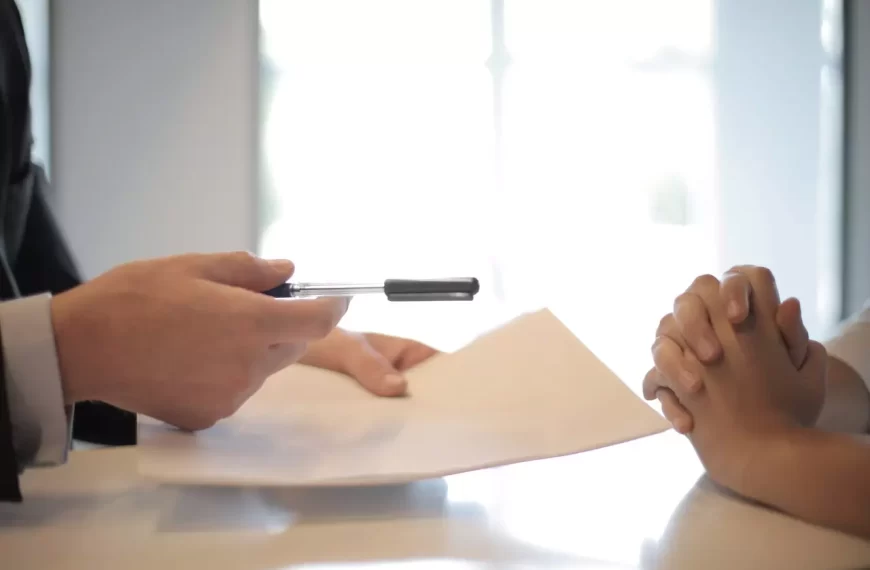 A business man giving a pen to sign a contract