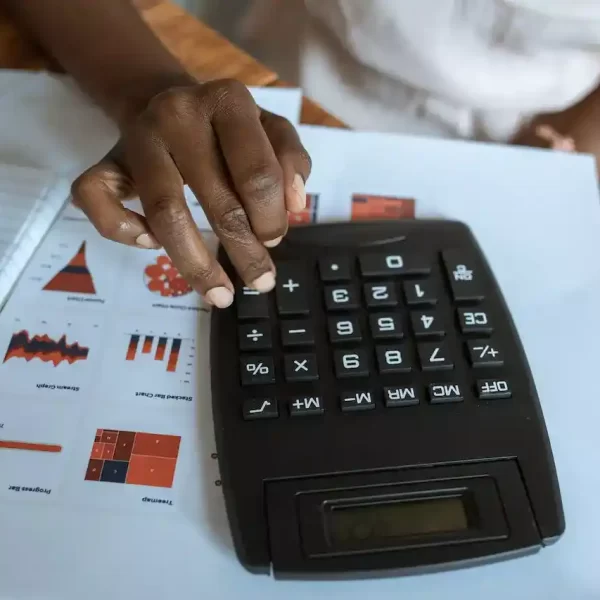 A person using a black calculator on a desk