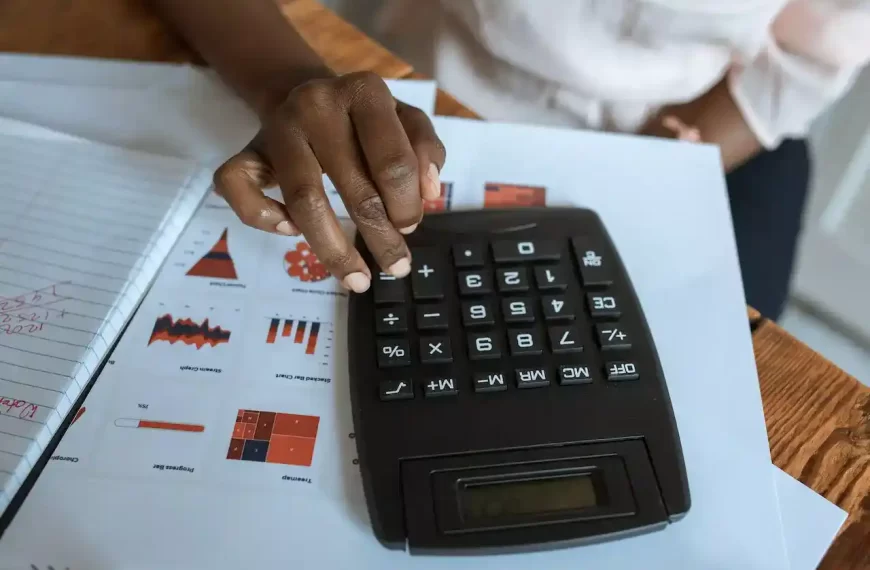 A person using a black calculator on a desk