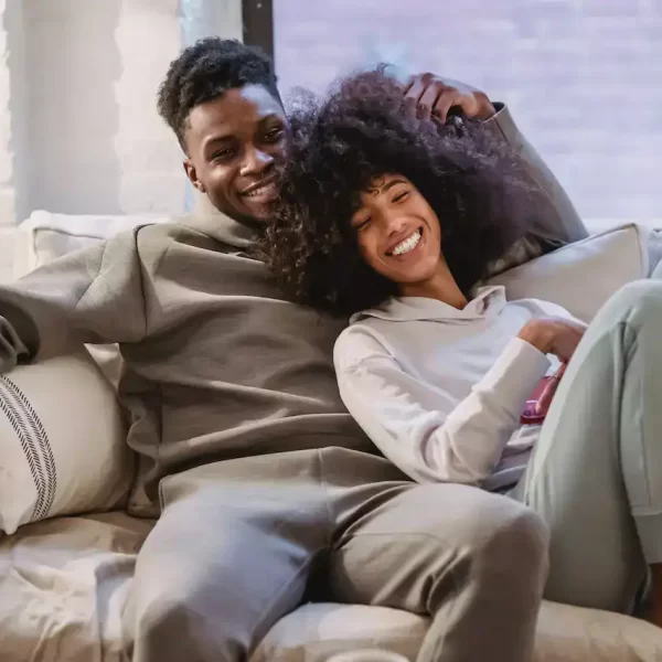 A black American couple cuddling on the couch