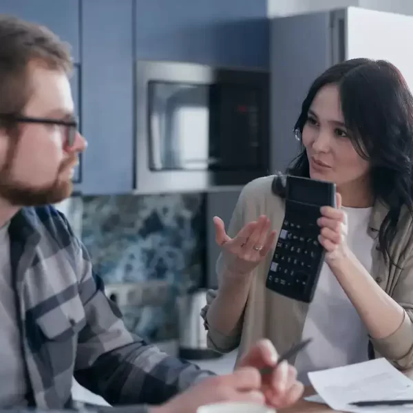 A woman showing a calculator to a man