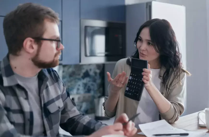 A woman showing a calculator to a man