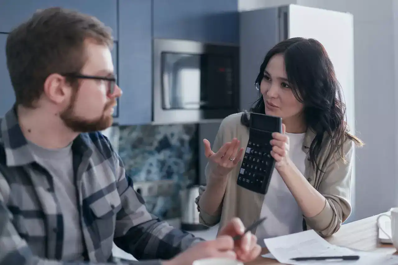 A woman showing a calculator to a man