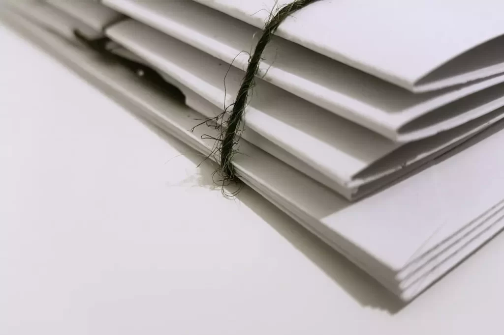 White paper folder with black string to keep them together