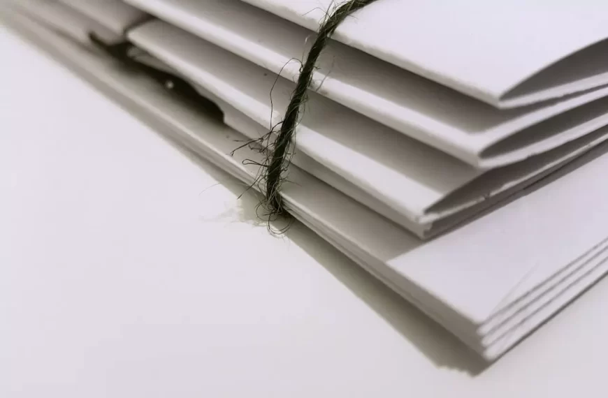 White paper folder with black string to keep them together