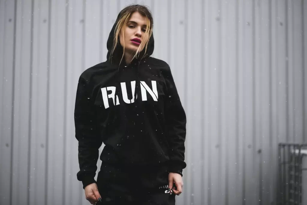 A woman wearing a black and white hoodie with "RUN" written on it