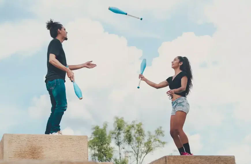 A man and a woman juggling together