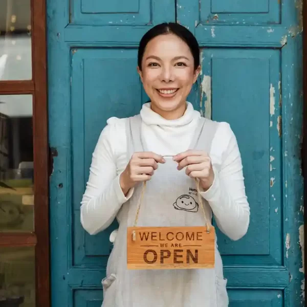 A woman standing in front of a door, smiling with a 