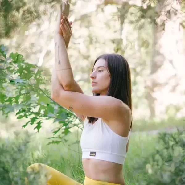 A woman doing yoga around plants