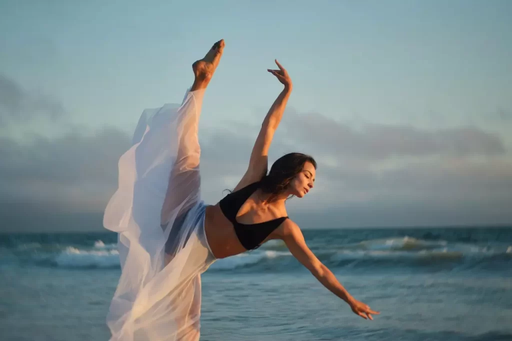 A slender dancer performing on coast of ocean with passion