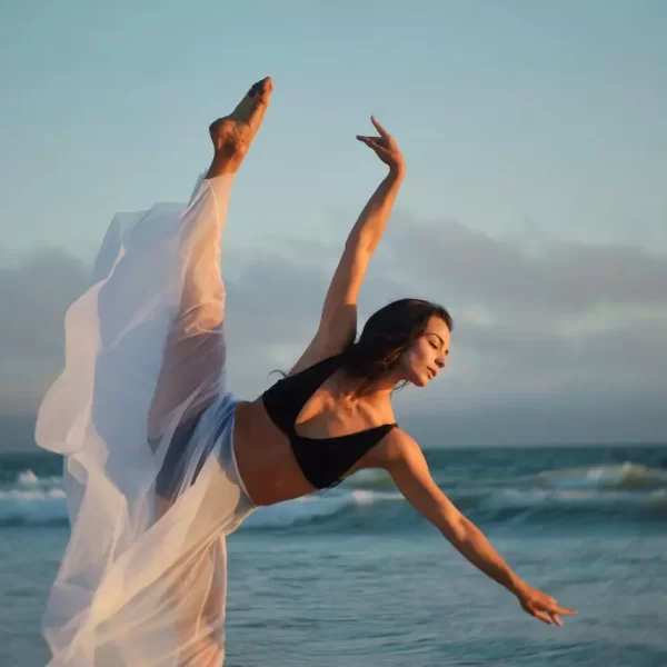 A slender dancer performing on coast of ocean with passion