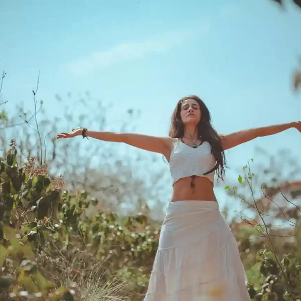 A woman spreading both her arms in a forest like place