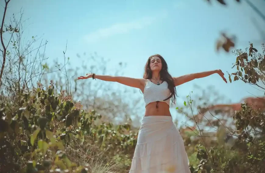 A woman spreading both her arms in a forest like place